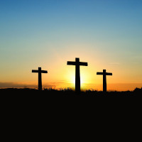 3 crosses on a hill - backlit by setting sun