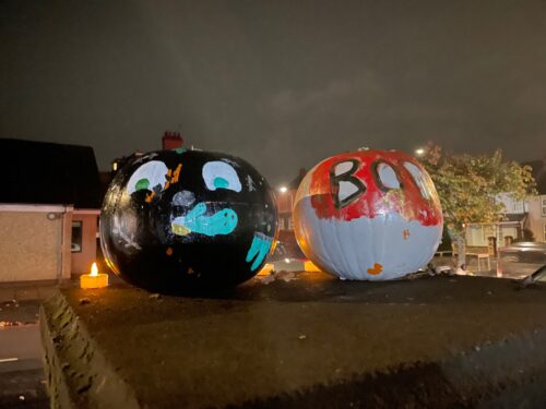 Pumpkins decorated sitting on the top of the wall in Windsor Gardens.